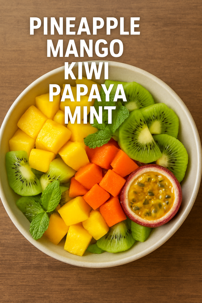 A bowl of tropical fruit salad with pineapple, mango, kiwi, papaya, and mint leaves, with the text "PINEAPPLE MANGO KIWI PAPAYA MINT". 